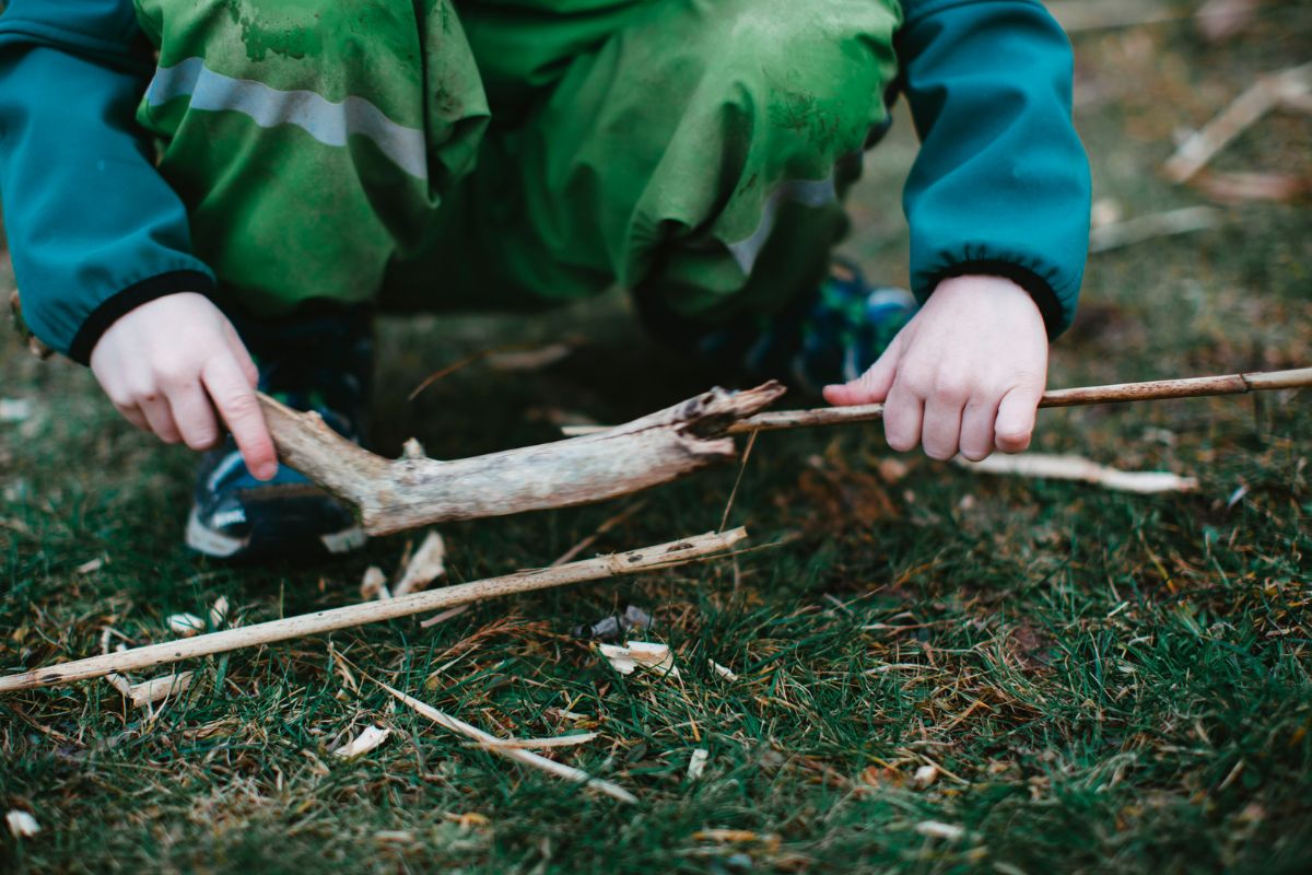 Child playing with sticks of wood